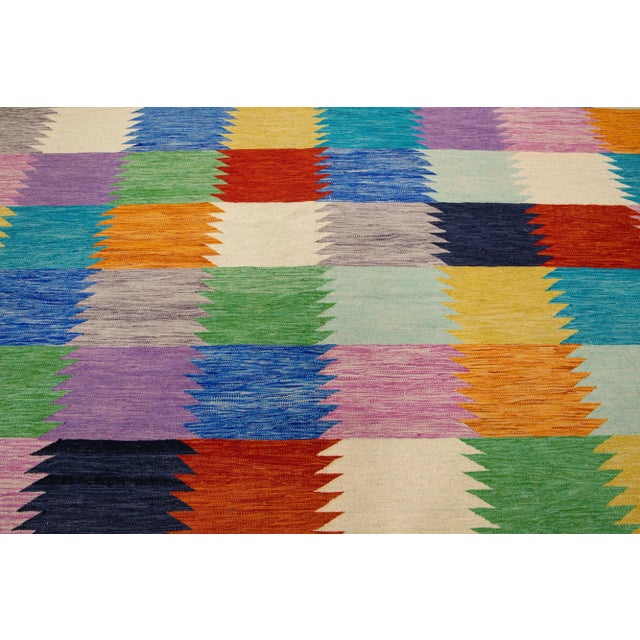 Beautiful Modern Kilim flatweave wool rug with a multicolor color field features a gorgeous geometric pattern design. This...