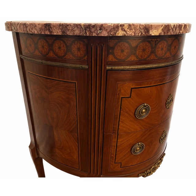 A beautifully proportioned French Louis XVI style demilune chest crafted in kingwood and topped with breche violette...