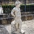 Life-size cast stone figure of Hermes with Aesculapian staff and winged helmet. He is leaning casually against a small...