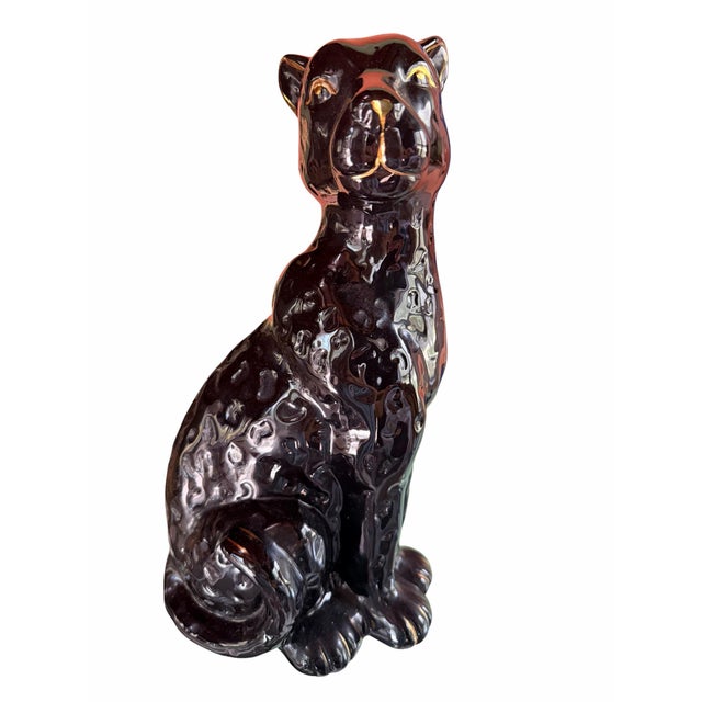 A fabulous vintage ceramic cat sculpture with a dramatic high-gloss black glaze and elegant gold-painted facial details....