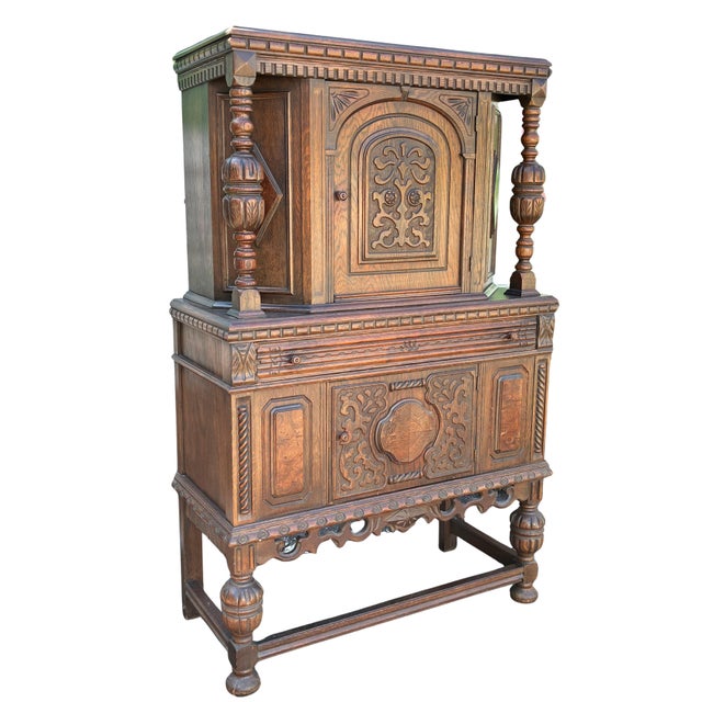 Handsome early 20th-century Jacobean Revival court cupboard crafted in richly grained oak and extensively decorated with...