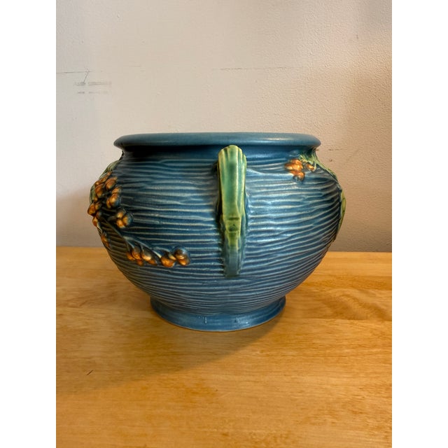 Roseville Bushberry line is characterized by its molded relief decoration of berries and leaves, often in vibrant...