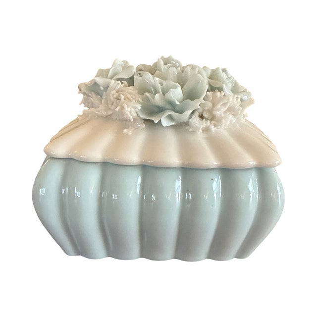 Charming vintage porcelain trinket box in a soft pale blue and white palette with a beautifully detailed floral lid. The...