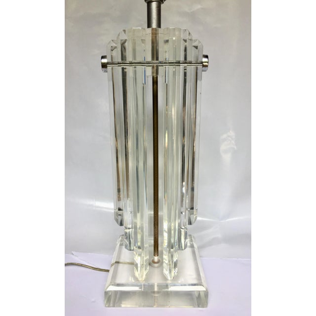 Large Hollywood Regency style Lucite table lamp featuring thick heavy stacked clear Lucite panels held together with...