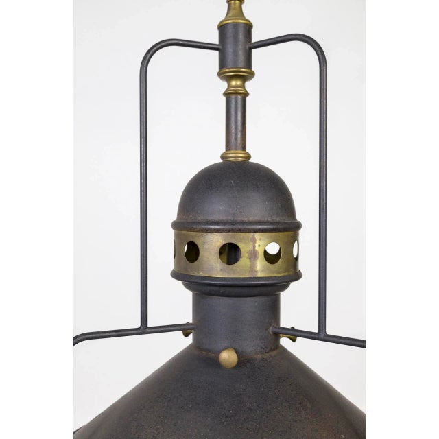 A large, unique, mixed metal light in dark bonze color with brass accents. The cogs were used to move the light along the...