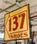 Reclaimed double sided movie set sign made of aluminum in red and yellow. The sign reads "137 SHOES". This was made to...