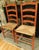 A handsome pair of traditional ladderback chairs featuring a deep red wood finish that enhances the natural grain and...