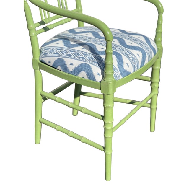 Believed to be manufactured by Kittinger, Pair painted faux bamboo armchairs. Upholstery is Blue/White Ikat and is...