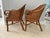 Vintage Tommy Bahama style bamboo and wicker accent chairs, featuring a warm brown frame and tropical cotton upholstery....