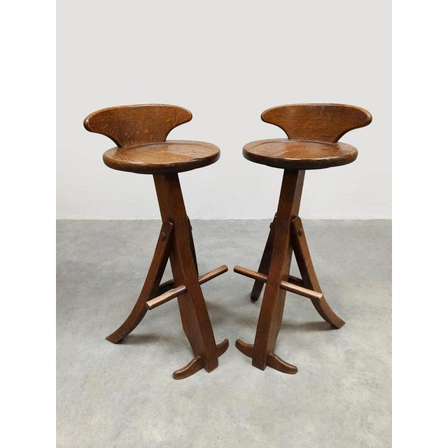 Absolute eye-catchers, this set of 2 wooden Brutalist bar stools. Period: 1960-1970. Country of origin: France. Designer:...