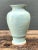 This vintage celadon ceramic vase brings a serene pale-green presence to a room through its lustrous glaze and finely...
