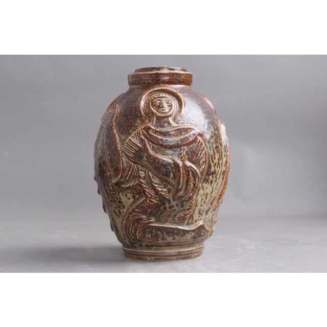Lidded jug by Jais Nielsen (1885–1969) for Royal Copenhagen. Sun-glazed stoneware lidded jug/urn with relief decoration...