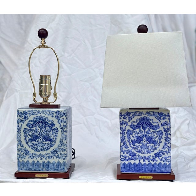 These classic blue and white porcelain chinoiserie table lamps feature a floral and koi fish design. These lamps, from the...