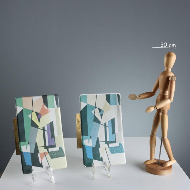 A pair of hard plastic and brass handles with a polychrome geometric print. The style is inspired by Italian Futurism and...