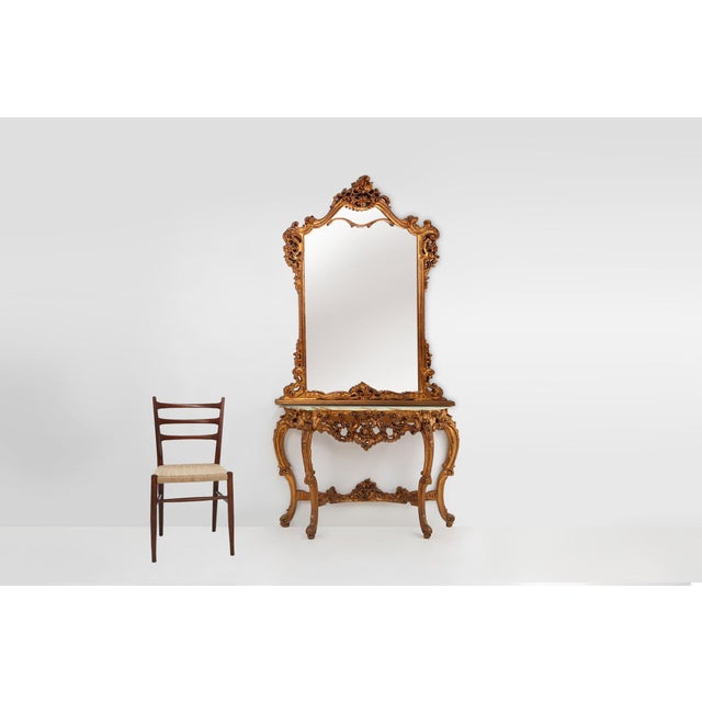 An elegant French console mirror from the 1970s, crafted in carved and gilded wood in the Louis XV style with Baroque...