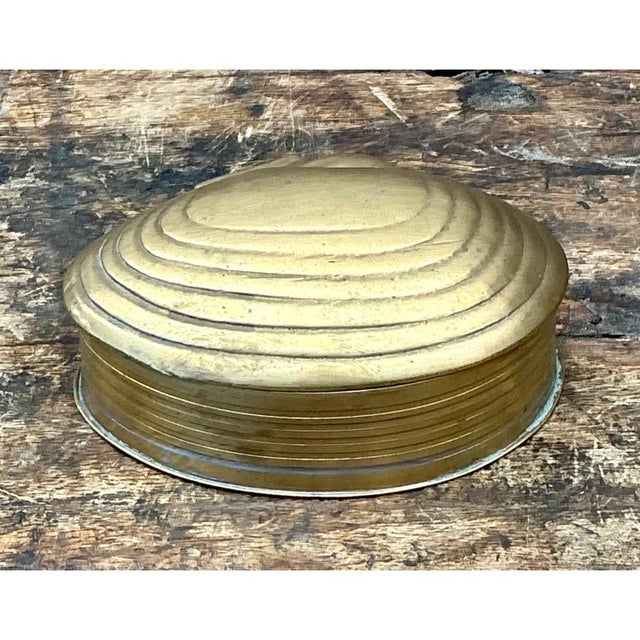 This vintage trinket box takes its form from a clamshell, its rounded, lobed silhouette rising into a gently domed lid...