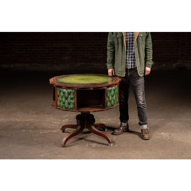Octagonal revolving séance or spirit table featuring a richly toned wood frame and a worn green leather writing surface...