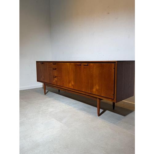 Impressive large-scale mid-century modern sideboard produced by Austinsuite , crafted in beautifully grained teak wood and...