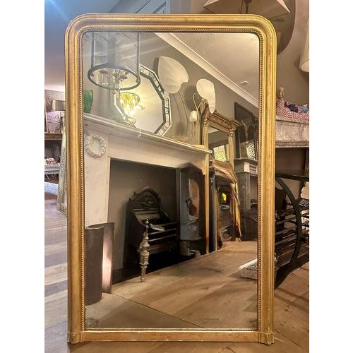 A tall Louis Philippe domed toped mirror in gold gilt and original mirror plate. The gilt work with a warm patina and red...