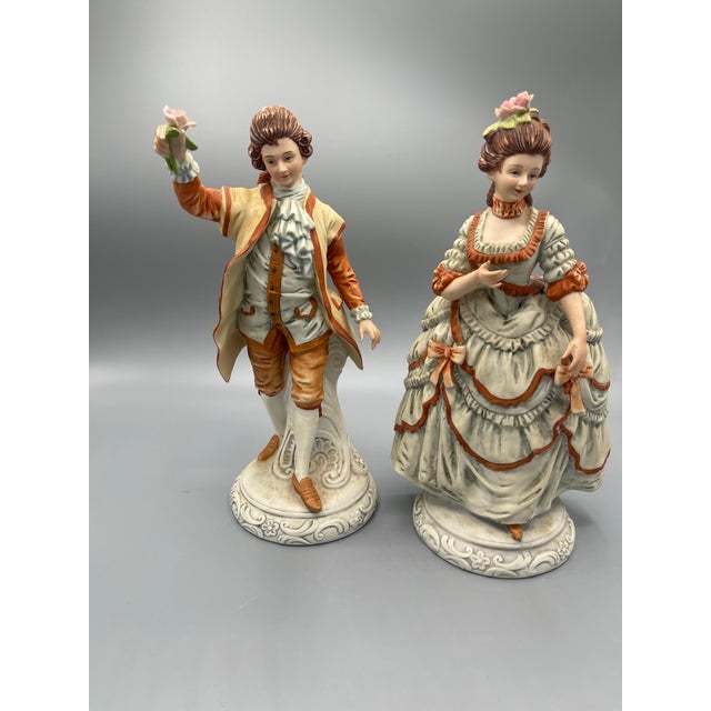 Pair of vintage Italian-style porcelain courting figurines featuring an elegantly dressed lady and gentleman in 18th-...