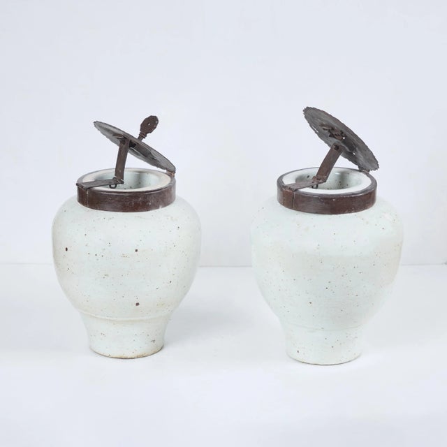Pair of Chinese porcelain, glazed tea jars with patinated metal covers and locks, 1 key.