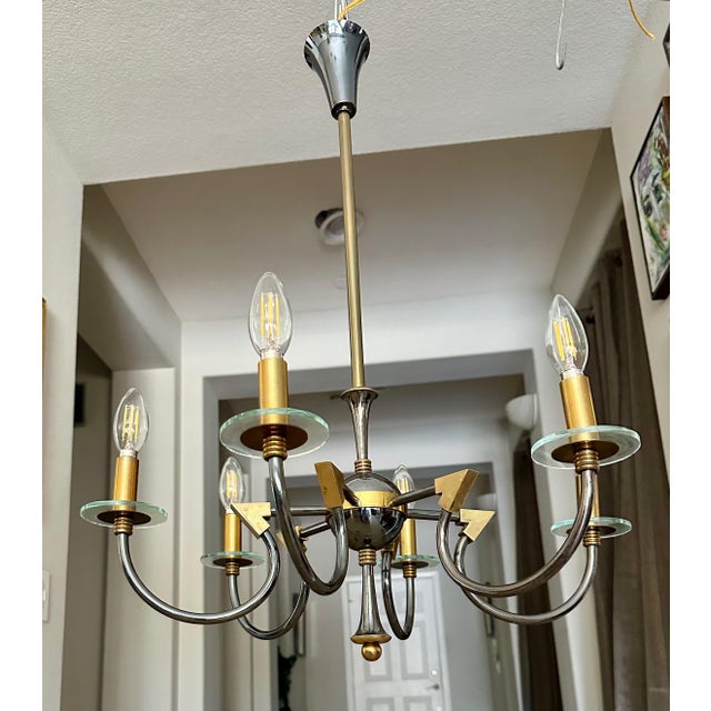 French moderne brass patinated six-arm chandelier, attributed tp Maison Lunel, France. Sleek detailing including curved...