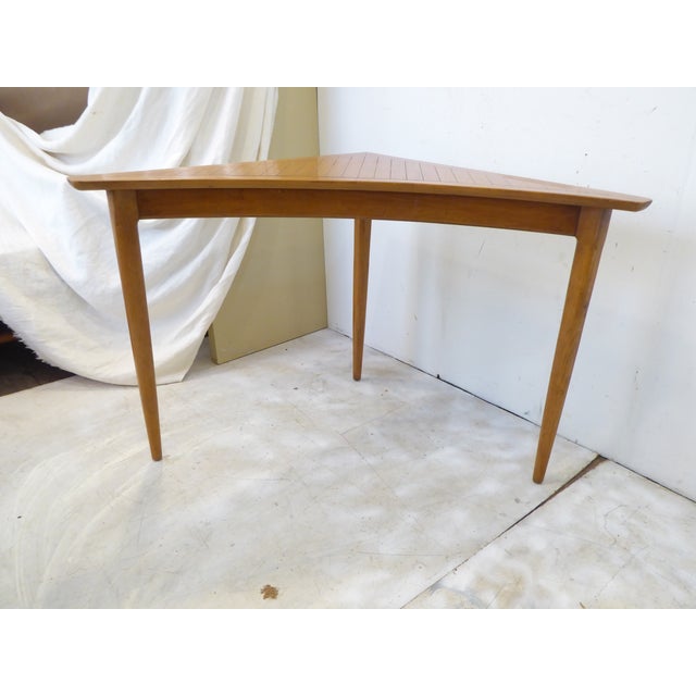 Modern hardwood corner table with three legs.