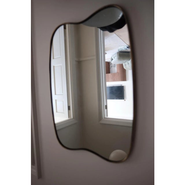 Midcentury Italian wall mirror attributed to Gio Ponti. Elegant golden brass frame with amazing shape, original crystal...