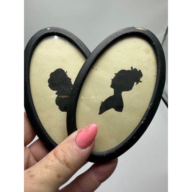 Charming pair of vintage silhouette portraits featuring elegant ladies in profile, beautifully presented in classic black...