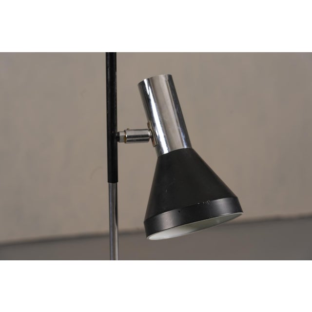 A vintage black 2-bulb floor lamp from Germany, produced in the 1970's. The designer and producer are unknown. Made from...