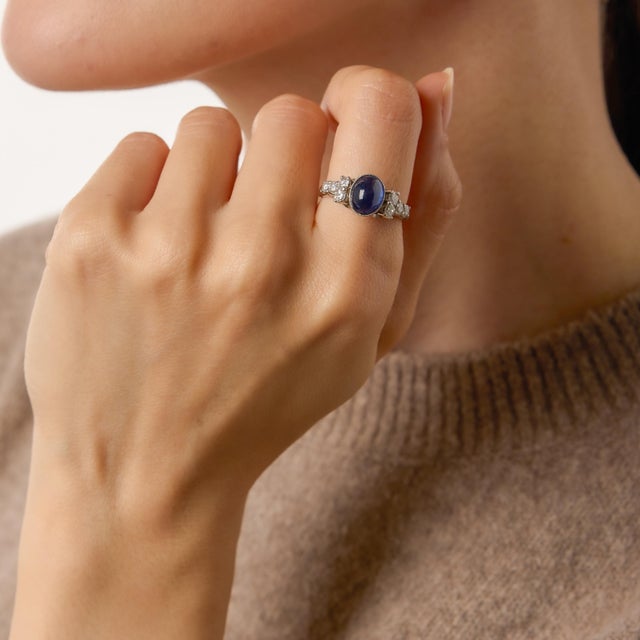A refined and captivating vintage design, this platinum ring centers on a luminous 2.63 carat cabochon cut sapphire. Its...