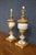 Pair of Italian Neoclassical table lamps featuring richly veined honey-toned and white alabaster in a classic urn form....