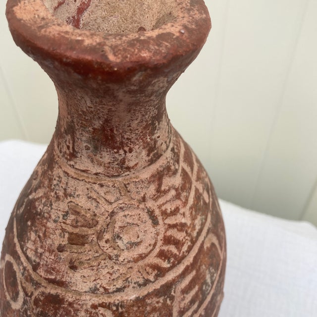 Elevate your space with this captivating 10-inch vintage primitive figural terracotta vase. Hand-thrown from organic red...