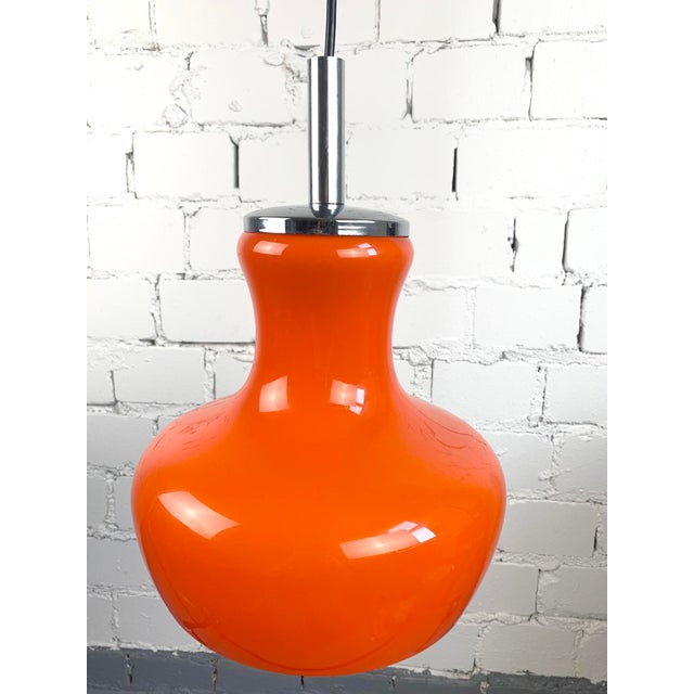 Vintage pendant lamp with orange glass shade and white interior. Chrome top detail. Gives a soft, warm light. • Glass:...