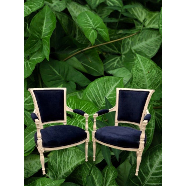The perfect classic small French arm chairs, a creamy wood finish with a resent new upholstery navy blue velvet.