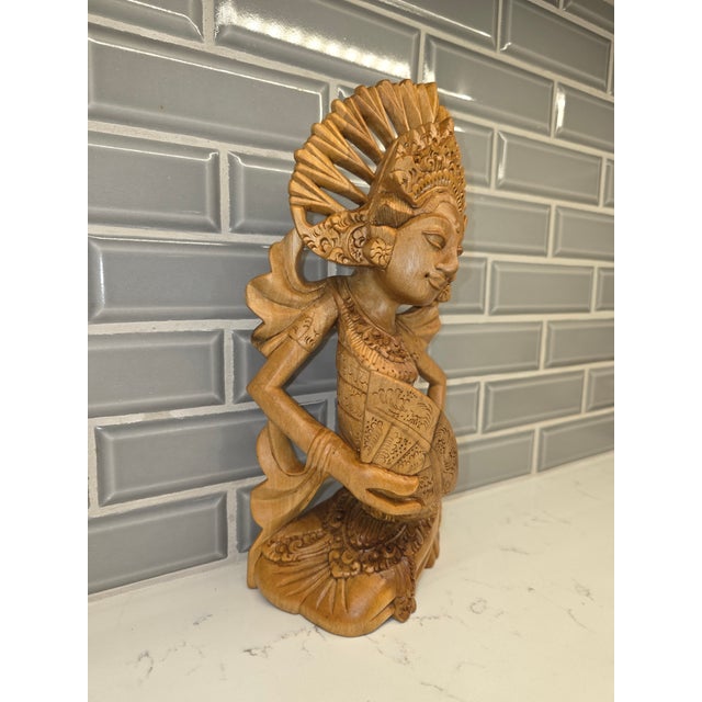 An extraordinary, highly detailed mid-century Balinese Art Deco sculpture depicting a seated Janger dancer gracefully...