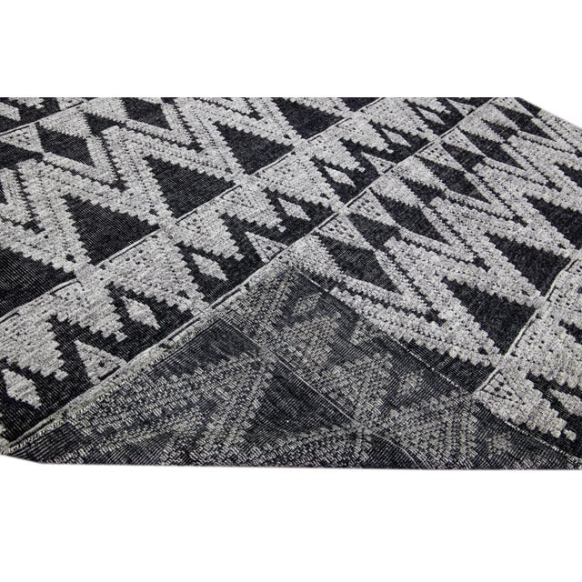 Beautiful modern Apadana's Safi Collection hand-knotted wool rug with a charcoal color field. This Modern rug has gray...