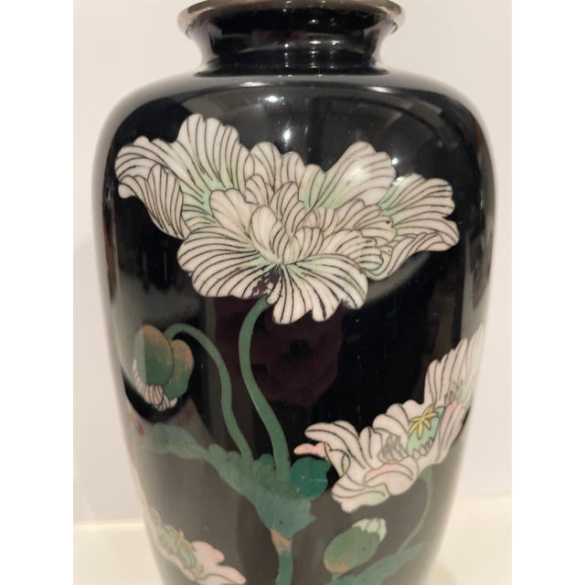 Mid 20th century Meiji style cloisonné vase with a black lacquer background and floral decoration. Metal base and mouth.