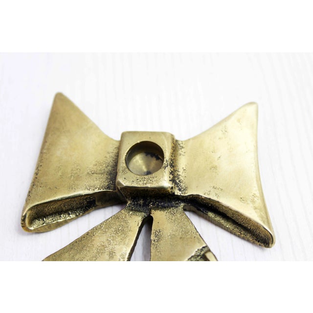 Beautiful brass candle holder from the 70s. This bow tie shaped candle holder hasn't aged a bit since the 70s. It offers a...