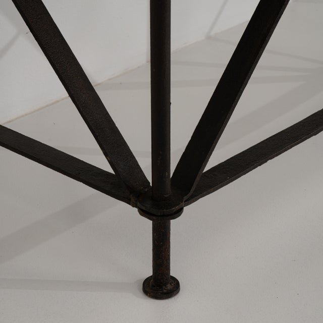 A wrought iron console table with a blue stone top. The structure features a simple industrial form with an emphasis on...