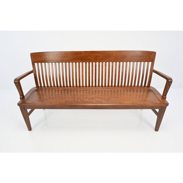 This beautifully refinished solid oak bench features a graceful, gently curved back with finely spaced vertical spindles,...