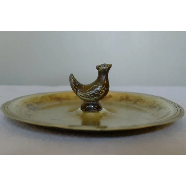 Danish ashtray with a figurine of a chicken from bronzed zinc on a brass bowl. This piece has an attribution mark, I am...
