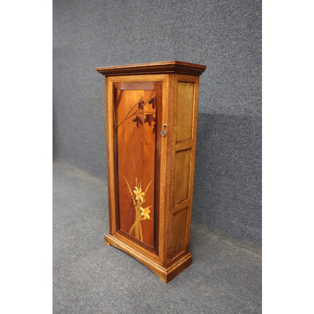 Early 20th-century Art Nouveau hanging pantry cupboard in the manner of Émile Gallé, crafted in quarter-sawn oak with an...