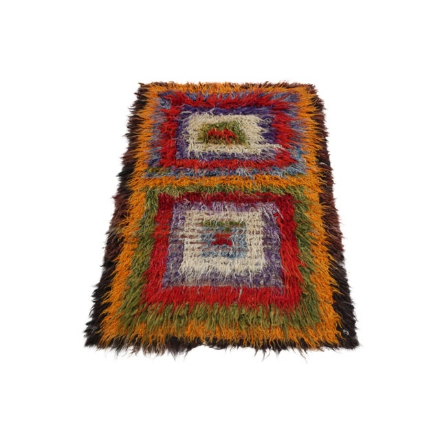 Coming from Turkey circa 1950-1960, this 4x7 vintage shag rug enjoys a resplendent high pile in ink blue, bright red,...
