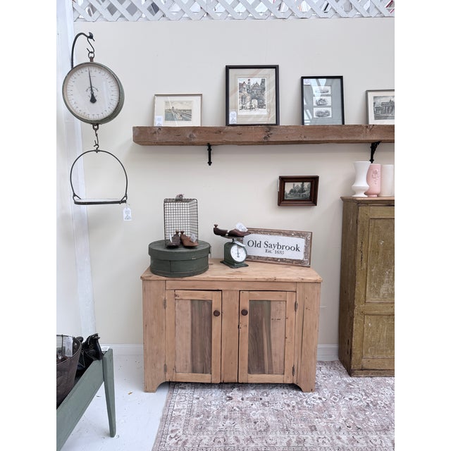 This antique scrubbed pine and ash cabinet has that wonderful blend of sturdiness and soul that only mixed‑wood country...