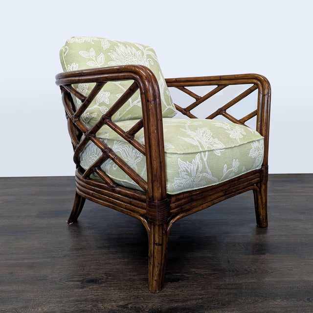 This stylish lounge chair features a sturdy rattan frame and comfortable green cushions with a delicate white floral...