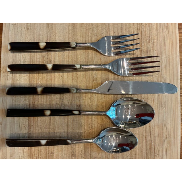 This set of flatware has dark brown resin handles streaked with black. Rivets and all metal parts are stainless steel....