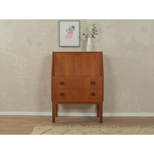 A classic secretary desk from the 1960s. High-quality teak veneer body with a hinged writing surface, two internal...