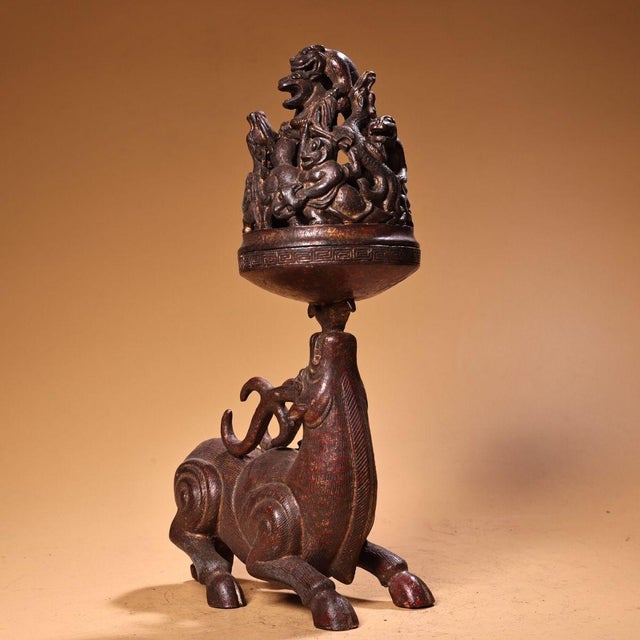 This is a cast bronze incense burner in the classic Boshan censer form, featuring a mountain-shaped lid adorned with a...