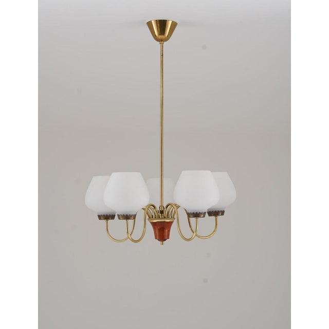 This elegant 1950s chandelier, manufactured by asea, showcases a sophisticated blend of brass and wood. Its graceful...